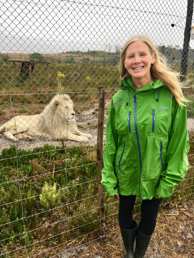 We are all connected, by Nancy Addison. Picture of nancy with rescued lions behind her.